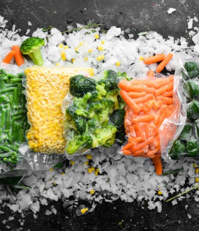 Surtido de verduras congeladas sobre hielo. Existencias de alimentos. Vista desde arriba. Espacio libre para su texto.